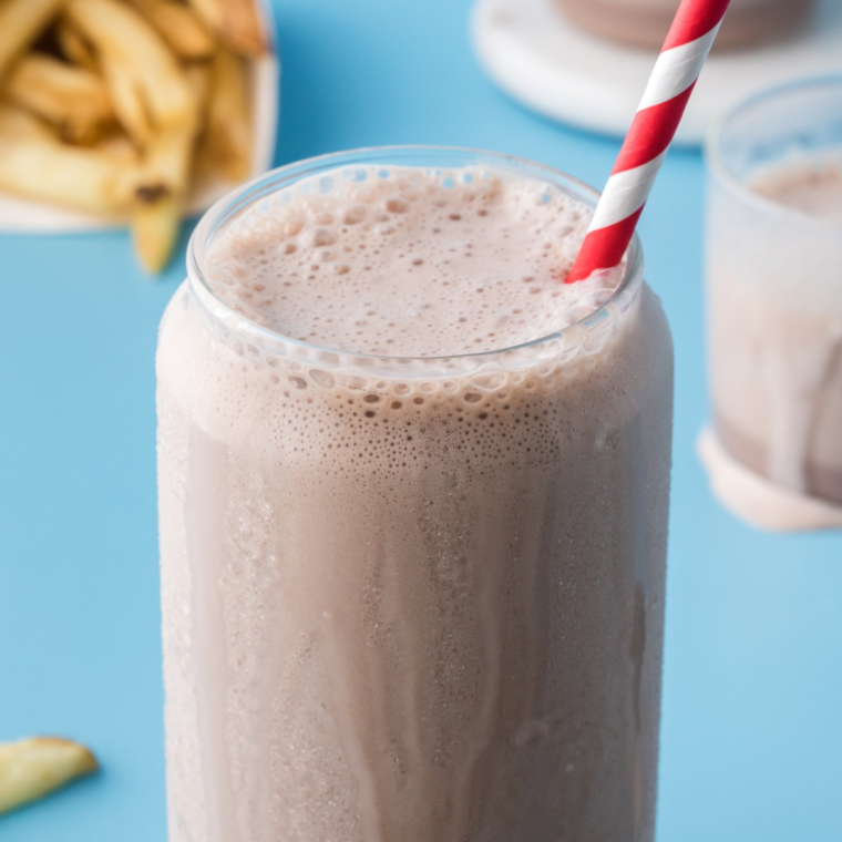 A creamy and chocolatey Ninja Slushi Copycat Frosty served in a glass, topped with a spoon, ready to enjoy.