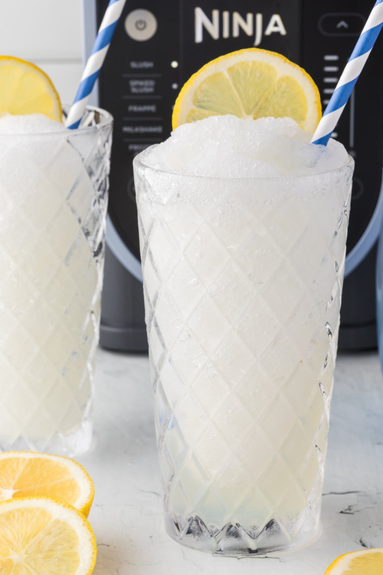 Ninja Slushie Hard Lemonade served in a glass with ice, garnished with a lemon slice for a refreshing, icy drink.