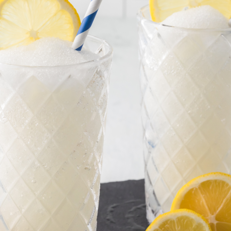 Ninja Slushi Hard Lemonade in a glass, icy and refreshing, with a lemon slice garnish."