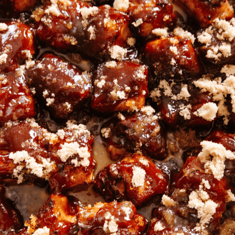 Top pork belly with butter, brown sugar, and barbecue sauce, then cover with aluminum foil.