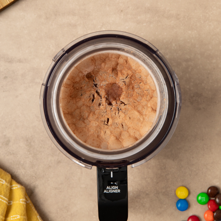 Processing frozen ingredients in a Ninja® CREAMi® Ice Cream Maker on the Lite Ice Cream and Re-Spin settings.