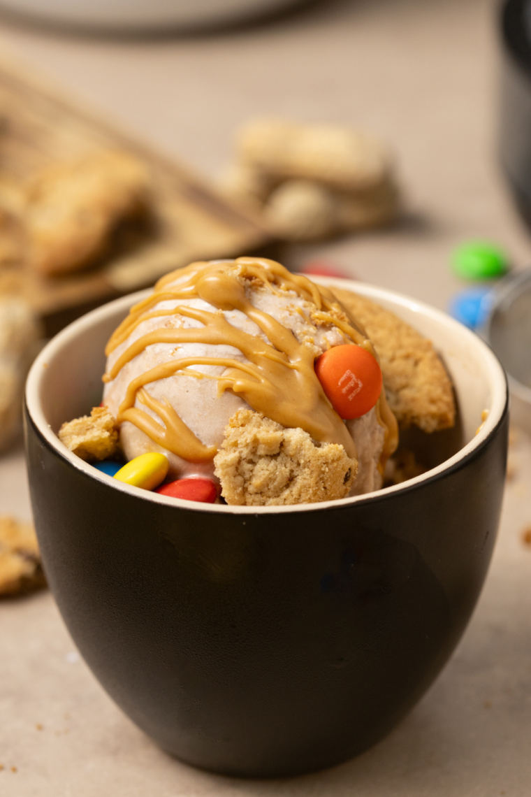 "Protein Monster Cookie Ninja Creami Ice Cream topped with M&M’s, cookie crumbles, and peanut butter swirls."