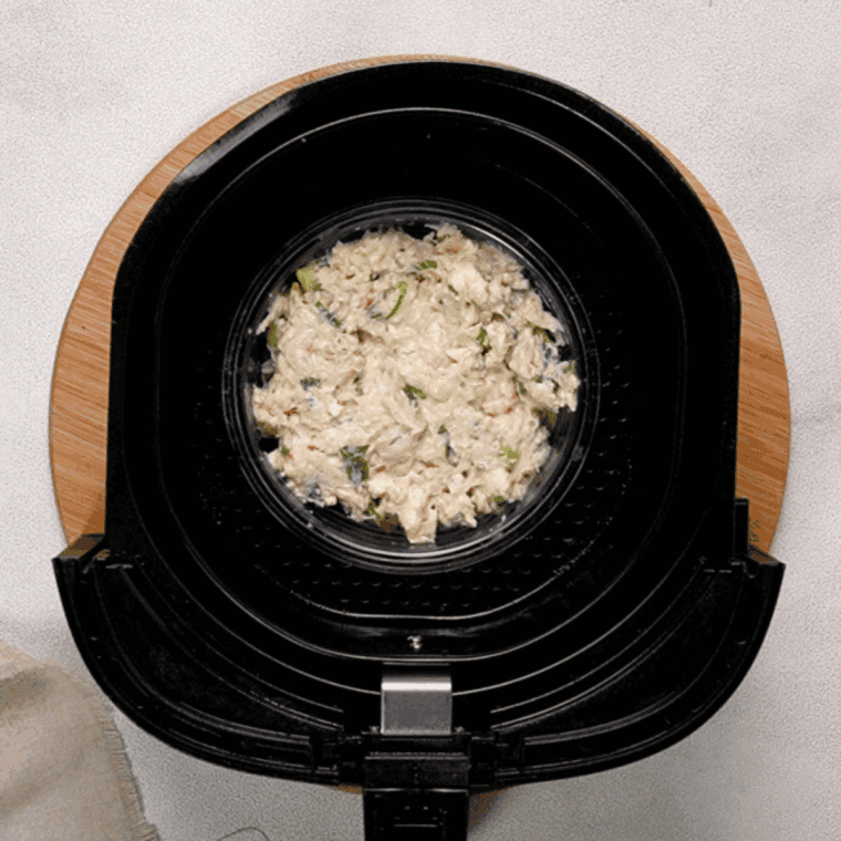 Generously sprinkle shredded cheese on top of crab meat and fries, ready to melt into a delicious dish.