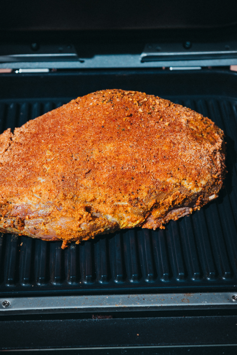 Placing brisket on Ninja Woodfire grill: "Cooking the seasoned brisket on the Ninja Woodfire grill for the perfect smoky flavor."