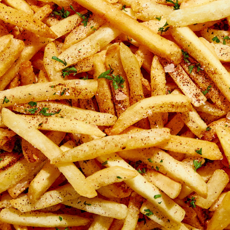 A bowl of Copycat Wingstop Fry Seasoning featuring a flavorful blend of spices, ready to sprinkle over golden French fries.