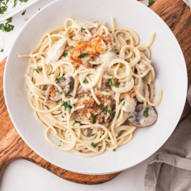 "A plate of creamy Air Fryer Chicken Tetrazzini topped with golden, crispy breadcrumbs and fresh parsley."