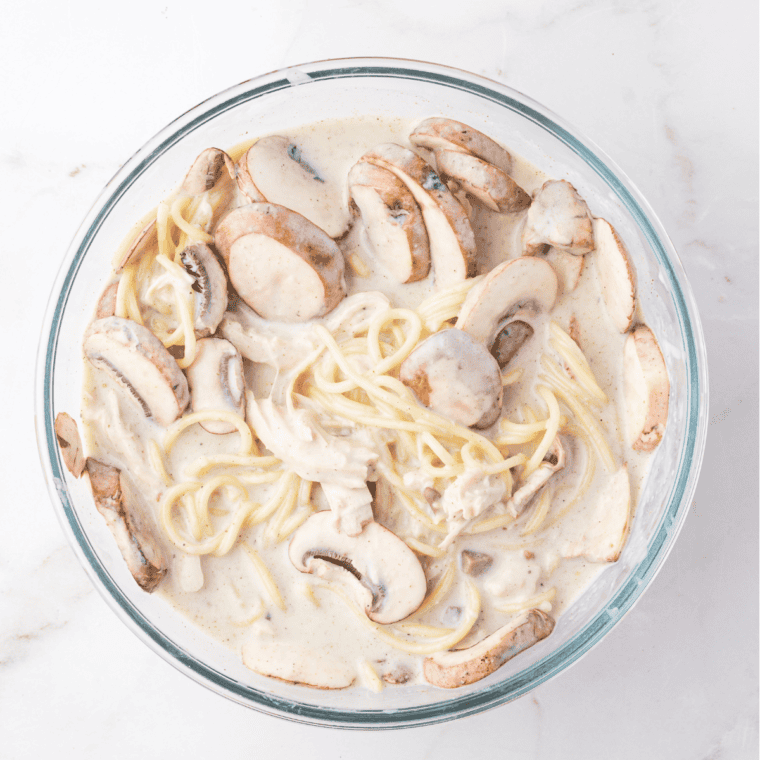 Whisking cream of mushroom soup, heavy cream, chicken broth, and seasonings in a large bowl.