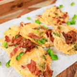 Golden and crispy Air Fryer Jalapeño Popper Crisps topped with melted cheese and bacon pieces, served on a plate.