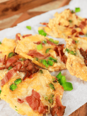 Golden and crispy Air Fryer Jalapeño Popper Crisps topped with melted cheese and bacon pieces, served on a plate.