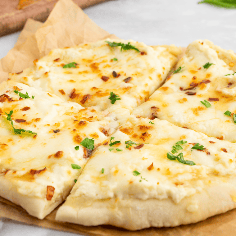 Golden, crispy Air Fryer White Pizza (Pizza Bianca) topped with ricotta, mozzarella, and fresh basil on a wooden board.