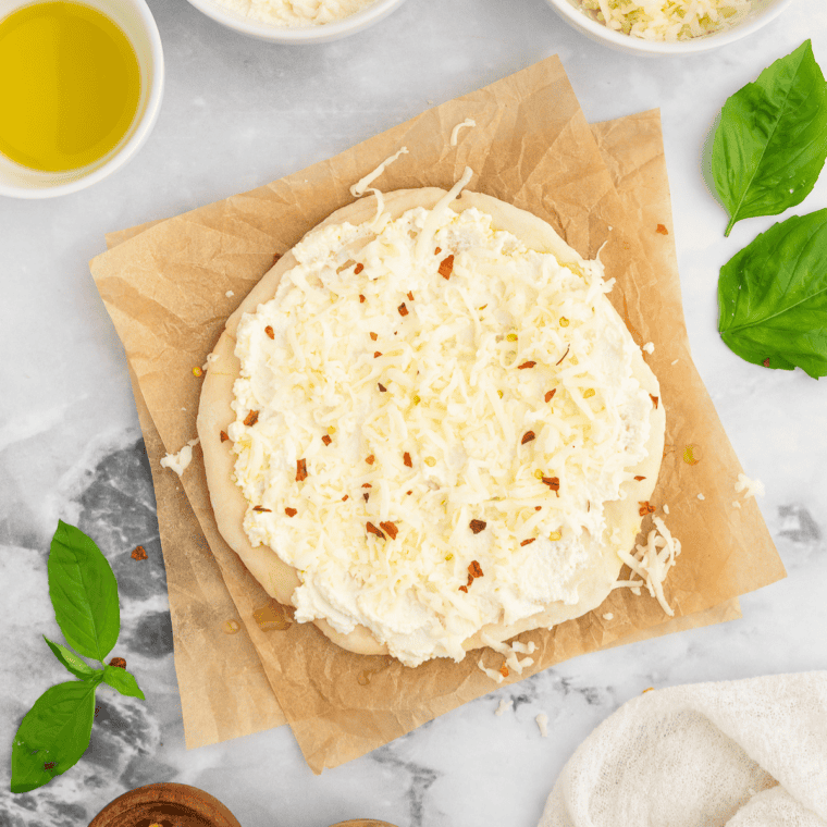 Pizza dough topped with creamy ricotta, shredded mozzarella, minced garlic, and Italian seasoning.