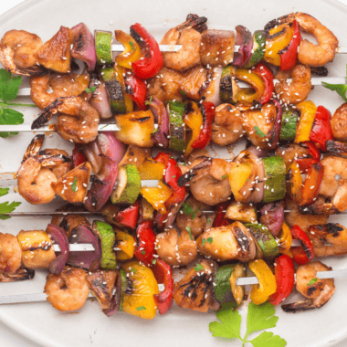 Grilled Blackstone Teriyaki Shrimp with a glossy glaze and garnished with green onions.