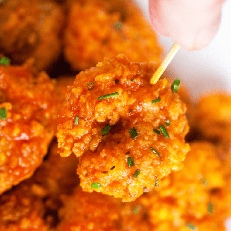 Shrimp coated with Buffalo Ranch Dressing, garnished with fresh herbs and served as a flavorful appetizer.