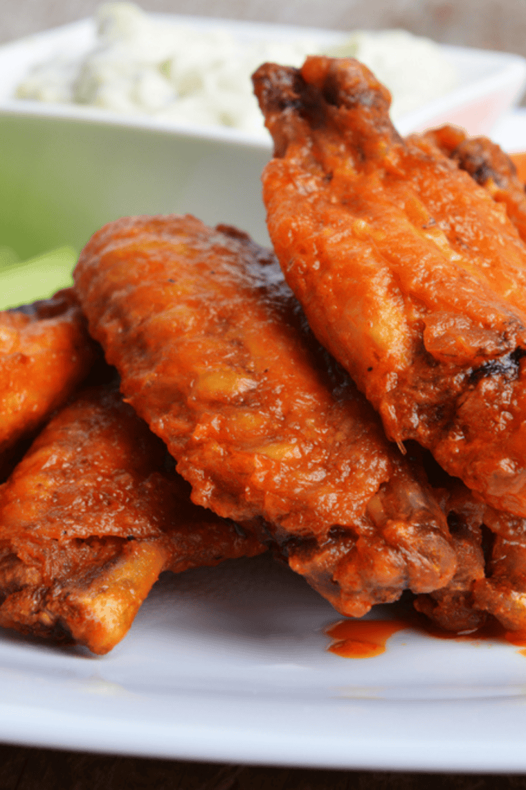 A bowl of creamy Buffalo Ranch Dressing with a swirl of buffalo sauce and garnished with fresh herbs.