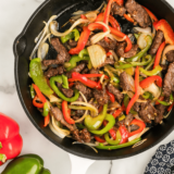 Caramelized peppers and onions cooked to golden perfection in a cast-iron skillet, ready to be served.