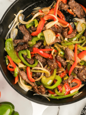 Caramelized peppers and onions cooked to golden perfection in a cast-iron skillet, ready to be served.