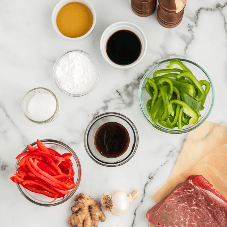 Ingredients needed for Caramelized Peppers & Onions on kitchen table.