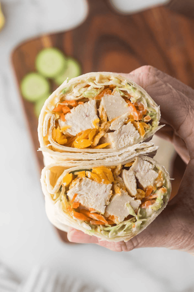 Homemade Chick-fil-A Grilled Chicken Cool Wrap filled with crispy chicken, lettuce, carrots, cucumber, and cheddar cheese wrapped in a tortilla.