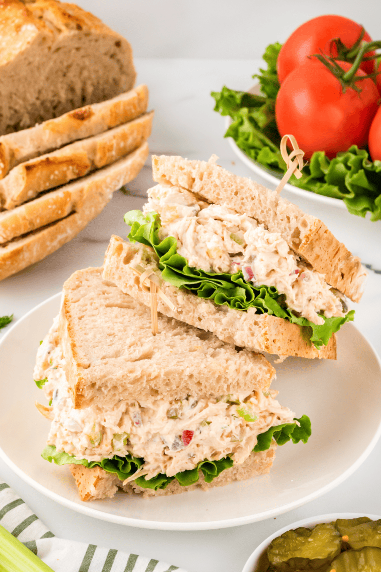 A bowl of creamy Copycat La Madeleine Chicken Salad with shredded chicken, celery, green onions, and almonds, served in a croissant.