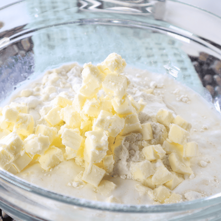 Mixing dry ingredients, butter, and buttermilk to form dough.