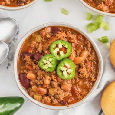 A hearty bowl of Copycat Steak ‘n Shake Chili topped with shredded cheese and served with crackers.