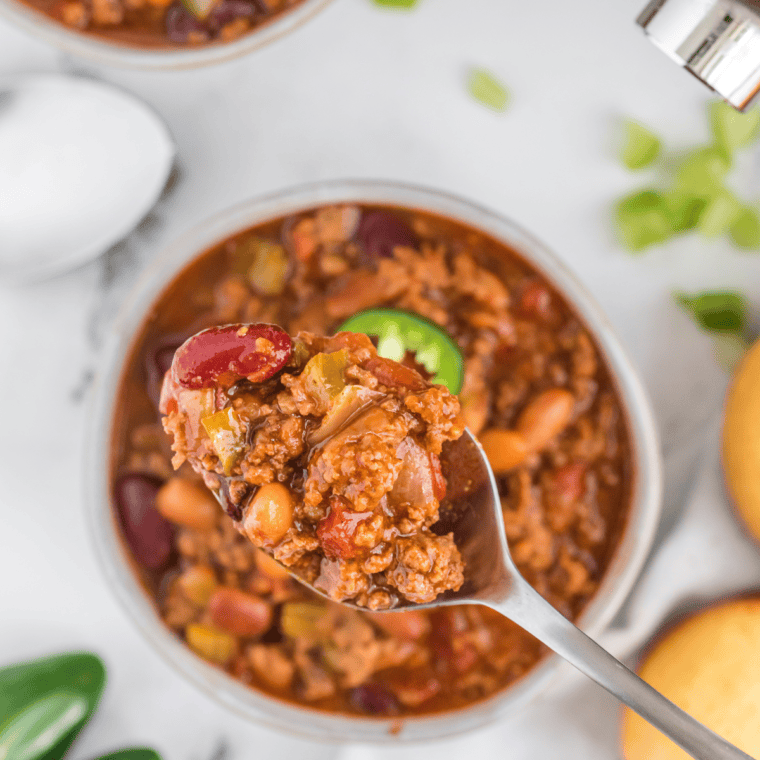 A bowl of homemade Copycat Steak ‘n Shake Chili garnished with fresh toppings.