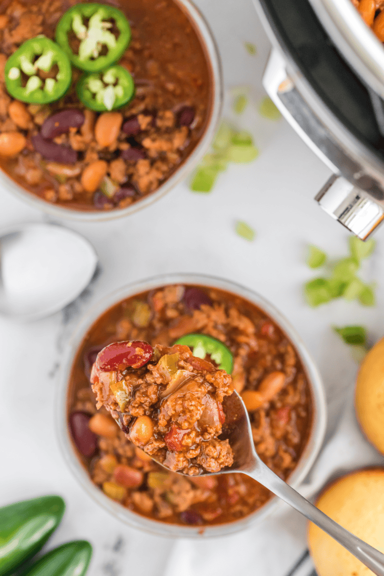 A bowl of homemade Copycat Steak ‘n Shake Chili topped with fresh garnishes.