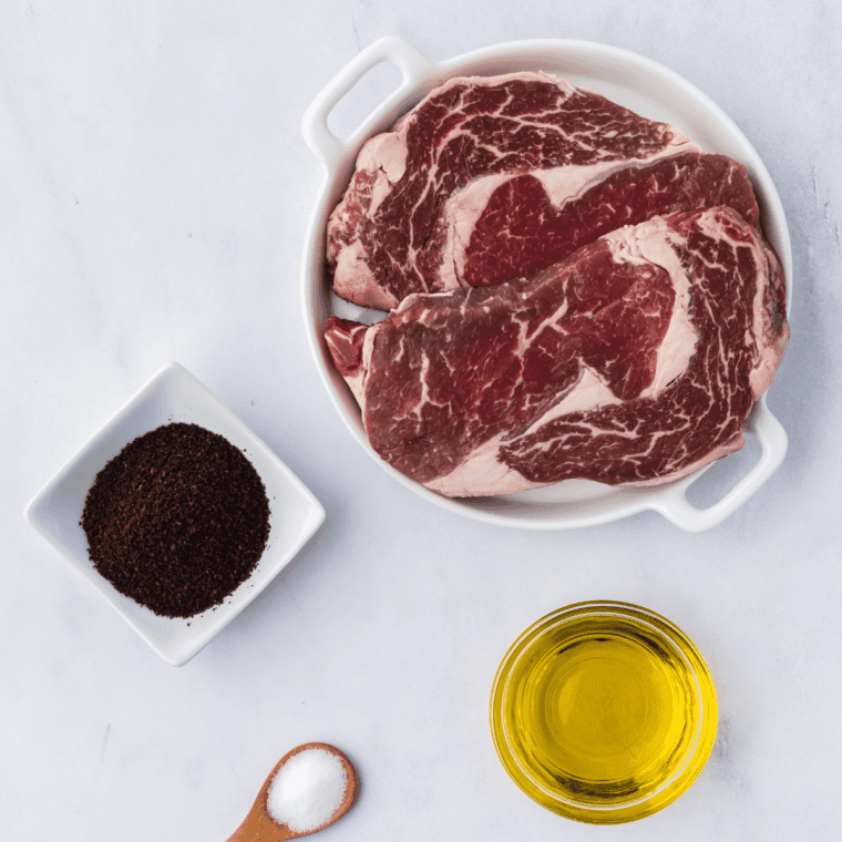 Ingredients needed for Ninja Foodi Grill Ribeye Steak on kitchen table.