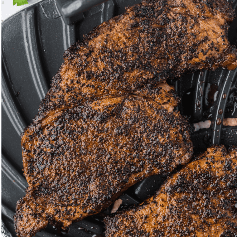 A perfectly seared ribeye steak cooked on the Ninja Foodi Grill, with a crispy crust and juicy, tender interior served on a rustic wooden plate.