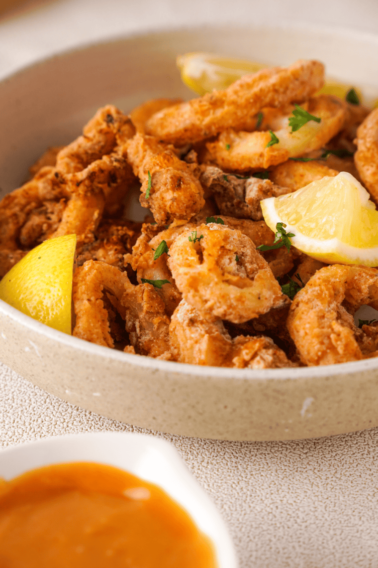 Crispy, golden Olive Garden-style calamari served with marinara dipping sauce and garnished with fresh parsley.