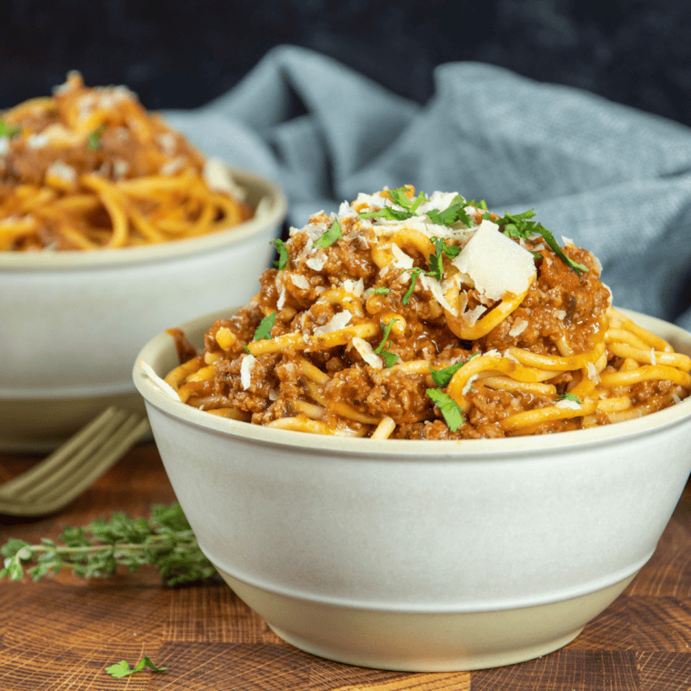 Olive Garden-style meat sauce simmering in a skillet with ground beef and Italian sausage, creating a rich, savory dish.