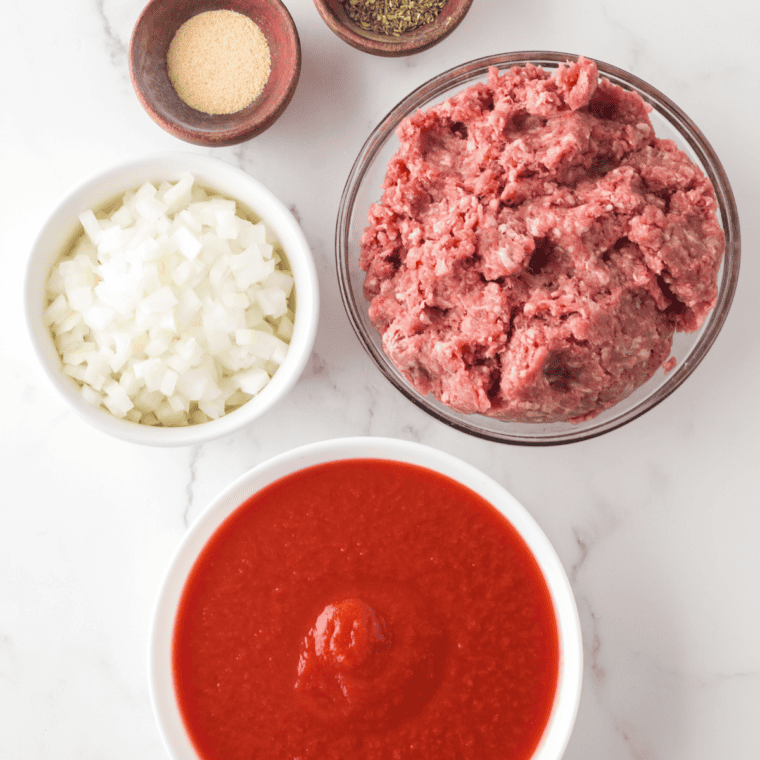 Ingredients needed for Olive Garden Meat Sauce on kitchen table.