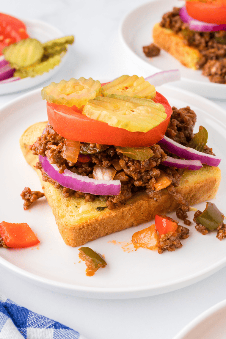 Open-Faced Sloppy Joes - Wahlburger Copycat with saucy ground beef and melted cheese on toasted bread, served on a plate.