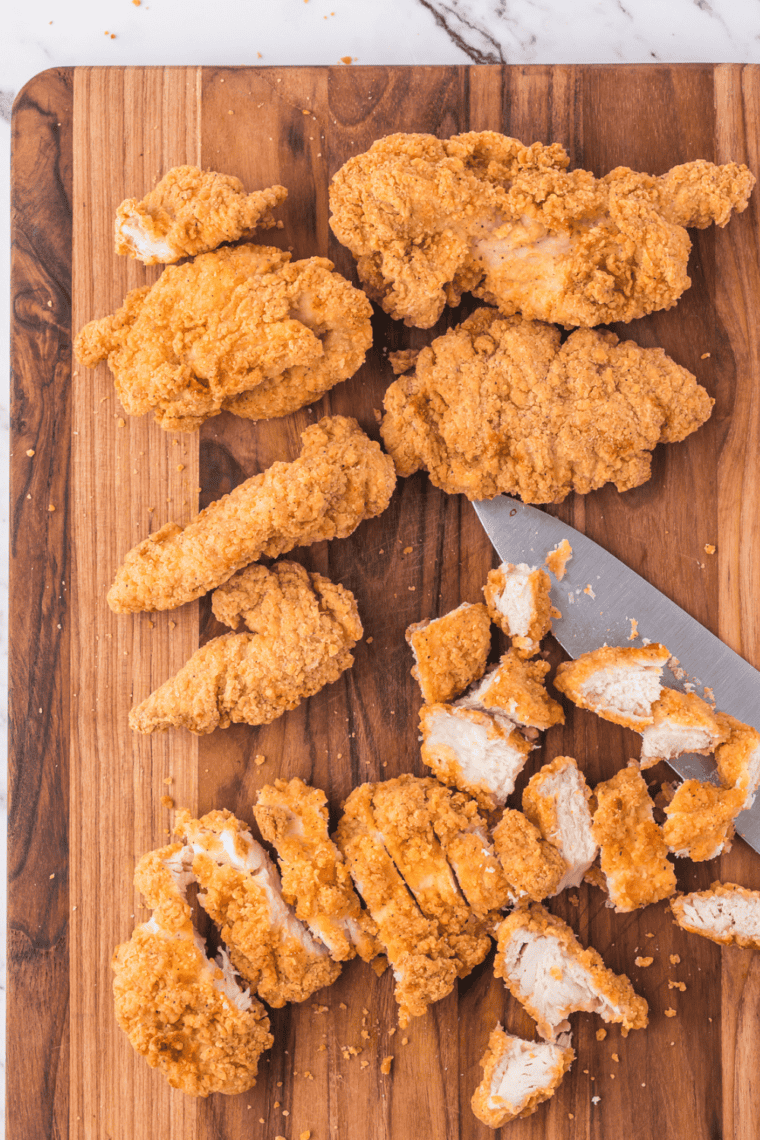 Slice the chicken tenders into bite-sized pieces on cutting board, with a sharp knife.