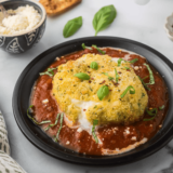 Crispy, golden-brown Air Fryer Burrata with a gooey, cheesy center, served on a plate with fresh basil and marinara sauce.