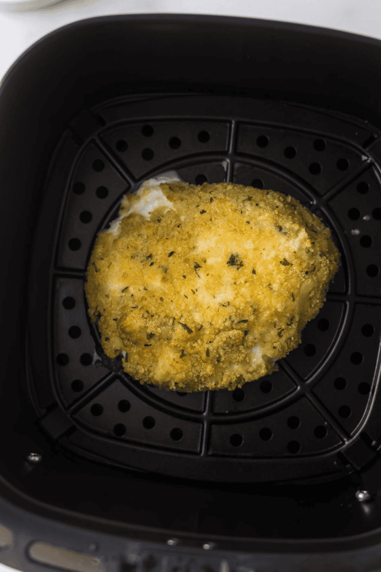 Placing the coated burrata ball in the air fryer basket, lightly sprayed with olive oil or cooking spray.