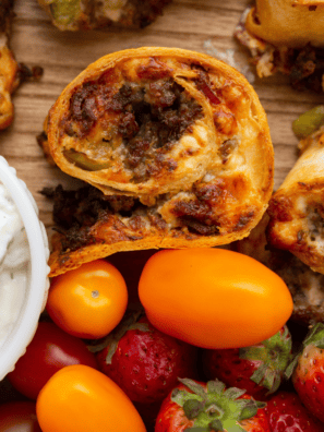 Golden, crispy Air Fryer Cuban Pinwheels filled with ham, Swiss cheese, pickles, and mustard, served on a plate.