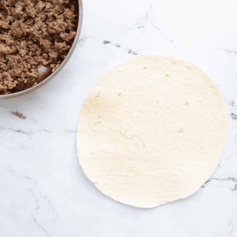 Seasoning sausage with salt, pepper, and paprika, then cooking for 1-2 minutes.