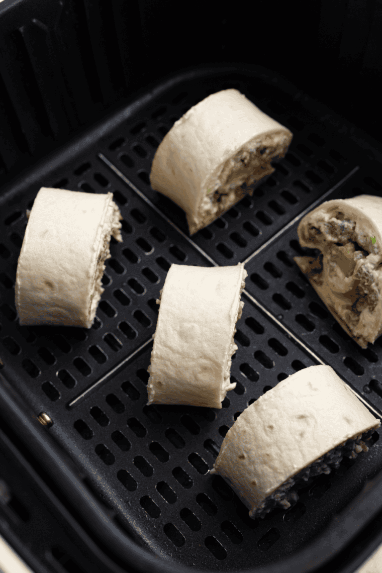 Placing pinwheels in the air fryer and cooking at 300°F for 3-5 minutes until crispy and golden.