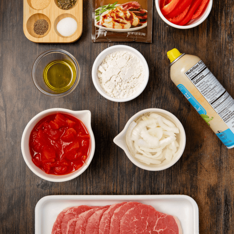Ingredients needed for Air Fryer Swiss Steak on wooden kitchen table.