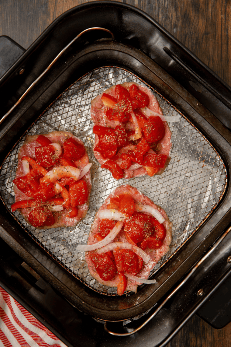 Steak topped with diced tomatoes, onions, bell peppers, and Italian seasoning, returned to the air fryer to cook until tender.