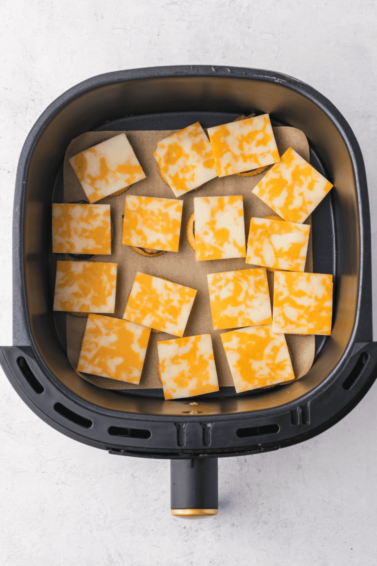 Arrange assembled Cheesy Ritz Pickle Bites in air fryer basket, ensuring no overlap, and cook at 375°F for 3-5 minutes until golden and crispy.