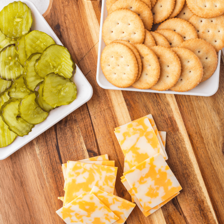 Ingredients needed for Cheesy Ritz Pickle Bites on kitchen table.