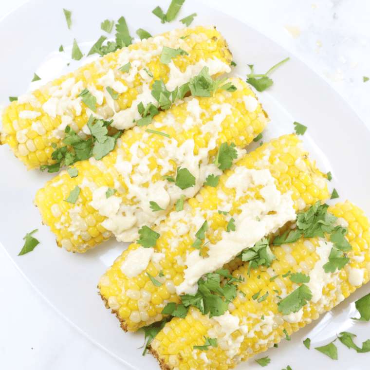 Chili's Roasted Street Corn with creamy dressing, cheese, and a sprinkle of spices on grilled corn