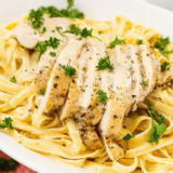 Delicious and creamy Copycat Carrabba’s Alfredo sauce served with pasta"