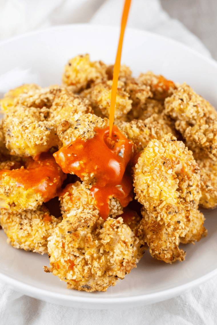 Homemade crispy copycat Popeyes popcorn shrimp served with dipping sauce.