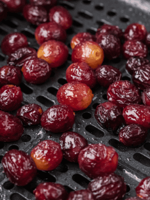 A tray of fresh grapes being dehydrated to make homemade raisins.