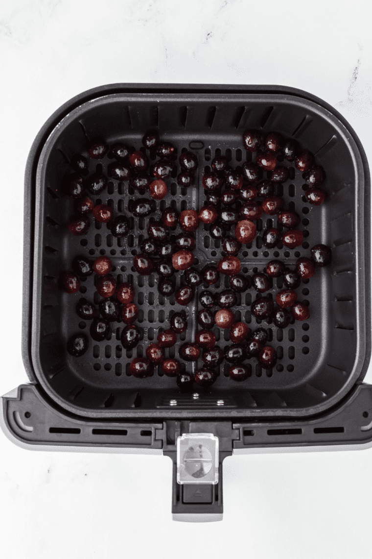 Grapes placed in a single layer in the air fryer basket for dehydrating.