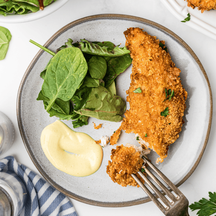 Crispy homemade KFC-style chicken strips ready to be served with dipping sauce.