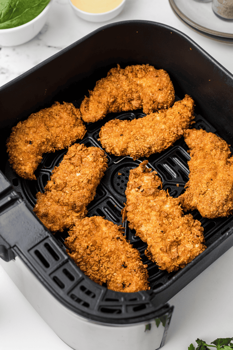 Golden crispy KFC-style chicken strips with a crunchy coating, served with dipping sauces